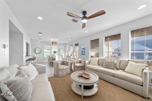 a living room with white furniture and a ceiling fan at Doc's Folly in Gulf Shores