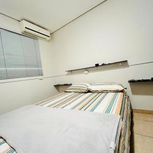 a bedroom with a bed and a window at Studio Palm Garden em Nova Andradina in Nova Andradina
