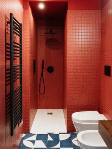 a bathroom with a toilet and a shower with red tiles at C’est la vie TAORMINA in Taormina +49 photos