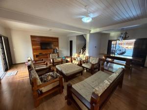 a living room filled with furniture and a flat screen tv at Sobrado prainha caioba in Guaratuba