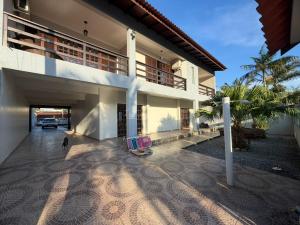 a building with two beach chairs in the courtyard at Sobrado prainha caioba in Guaratuba