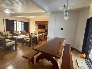 a living room with a large wooden table in it at Sobrado prainha caioba in Guaratuba +1 photo