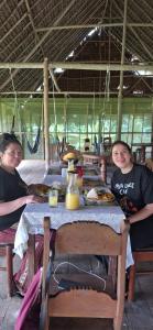 two people sitting at a table with food at Amazon Tropical Expeditions in Iquitos +21 photos