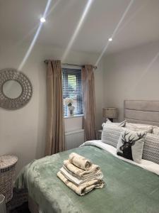a bedroom with a bed with a pile of towels on it at Cozy bungalow in Standish