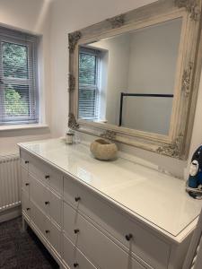 a dresser with a large mirror on top of it at Cozy bungalow in Standish +10 photos