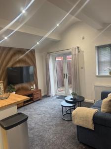 a living room with a couch and a tv at Cozy bungalow in Standish