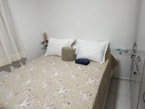 a bed with three pillows on it in a room at Alameda Jardim Serra Negra in Bezerros