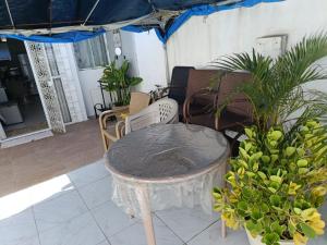 a table in a patio with chairs and plants at Alameda Jardim Serra Negra in Bezerros