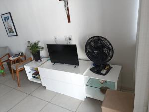a living room with a tv on a white cabinet at Alameda Jardim Serra Negra in Bezerros