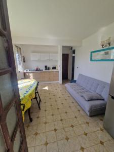 a living room with a blue couch and a kitchen at Holiday rental House in Schœlcher