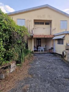 a house with a driveway in front of it at Holiday rental House in Schœlcher