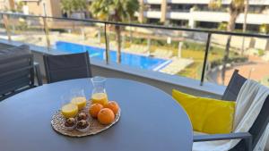 a plate of fruit and juice on a table on a balcony at MG Playa Flamenca Village in Orihuela Costa +44 photos