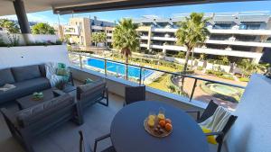 a balcony of a hotel with a table with fruit on it at MG Playa Flamenca Village in Orihuela Costa