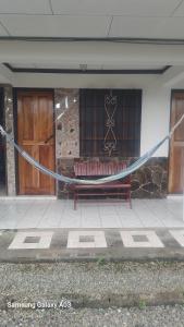 a bench with a hammock in front of a building at Cabinas Smith 2 in Cahuita