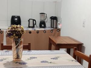 a kitchen with a table with a vase of flowers at hospedagem dos viajantes in Lençóis