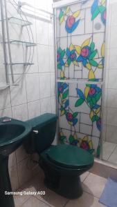 a bathroom with a green toilet and a stained glass window at Cabinas Smith 2 in Cahuita
