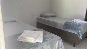 a room with two beds with white towels on top at Aquarius Hoteis Ltda in Canarana