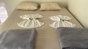 a bed with three pillows on top of it at Aquarius Hoteis Ltda in Canarana