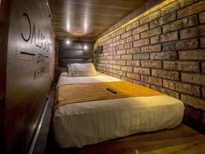 a room with two beds in a brick wall at Cadillac Hotel Boutique in Mexico City +108 photos