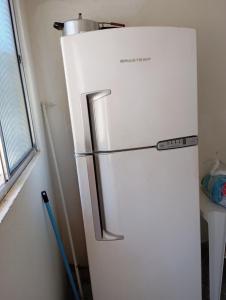 a white refrigerator in a room with a window at Kitnet Ateneu in Vila Velha