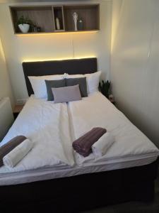 a large bed with white sheets and pillows at Tiny House Beilngries in Beilngries