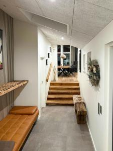 a hallway with stairs and a bench and a table at Architect-Designed House In Juelsminde in Juelsminde