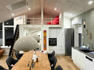 a kitchen with a table and chairs and a loft at Architect-Designed House In Juelsminde in Juelsminde