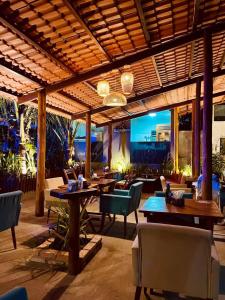 ein Restaurant mit Tischen und Stühlen und einer Terrasse in der Unterkunft Jimbaran Pousada & Bistrot in Maragogi