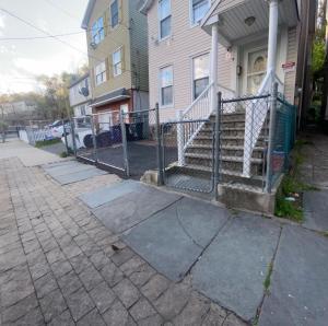 a fence in front of a house with stairs at Spacious Private Room with Private Bath in Paterson