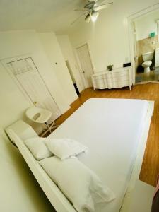 a white bed in a room with a ceiling fan at Spacious Private Room with Private Bath in Paterson