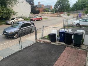 a car parked next to a fence with trash cans at Spacious Private Room with Private Bath in Paterson +1 photo