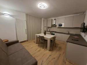 a kitchen and living room with a table and a couch at La cà de Clüsu in Clusone
