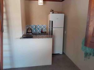 a kitchen with a white refrigerator in a room at Dell Ville Cabin in Barreirinhas