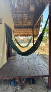 a hammock hanging from a roof on a deck at Dell Ville Cabin in Barreirinhas
