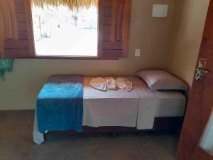 a small bed in a room with a window at Dell Ville Cabin in Barreirinhas