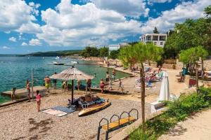 a group of people on a beach near the water at Master Road House in Maslenica