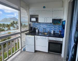 a kitchen with a balcony with a view of the ocean at Studio Ti Saphir in Le Diamant