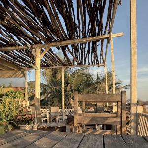 a wooden pergola with two benches on a deck at WHITE FLAT ALMADIES in Dakar