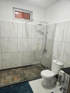 a bathroom with a white toilet and a window at I Love Tanque in Caculi +3 photos