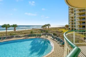 a balcony with a swimming pool and the beach at Beach Colony East Unit 1C in Pensacola