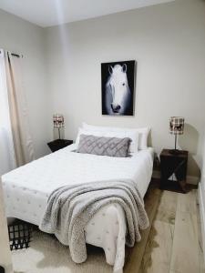 a bedroom with a large white bed with a blanket on it at Encuentro Vaquero in Jarabacoa