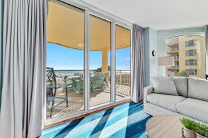 a living room with a couch and a balcony at Beach Colony East Unit 1C in Pensacola