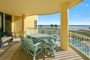 a table and chairs on a balcony with the beach at Beach Colony East Unit 1C in Pensacola