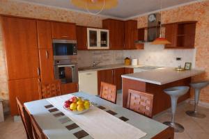a kitchen with a table with a bowl of fruit on it at Villa Bella Vista - For up to 6 people Villa with Sea & Castle view in Črni Kal