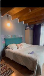 a bedroom with a bed with a green headboard at Casa Arrayán con vista al volcan in Frutillar