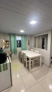 a dining room with a white table and chairs at Loft das Maritacas - Conservatória in Valença +4 photos