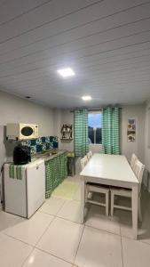 a kitchen with a table and a white table and chairs at Loft das Maritacas - Conservatória in Valença