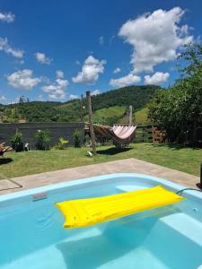 a swimming pool with a hammock in a yard at Loft das Maritacas - Conservatória in Valença