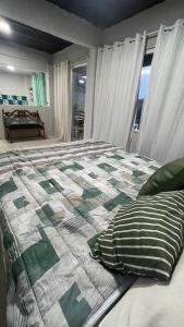 a bedroom with a bed with a green and white quilt at Loft das Maritacas - Conservatória in Valença
