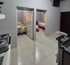 a room with two beds and a kitchen with a door at Sol in San Benito